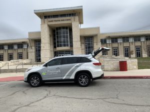 Firstmark Credit Union branded vehicle in front of Wagner High School.