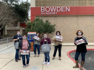Educadores sosteniendo máscaras frente a Bowden Academy.