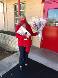 Educator holding masks and flowers at Fredericksburg ISD.
