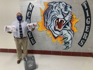 Educator holding masks at Scobee Middle School.