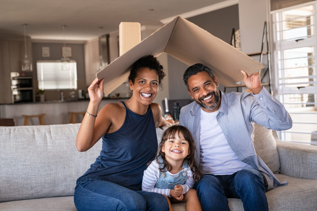 New homeowners holding cardboard roof